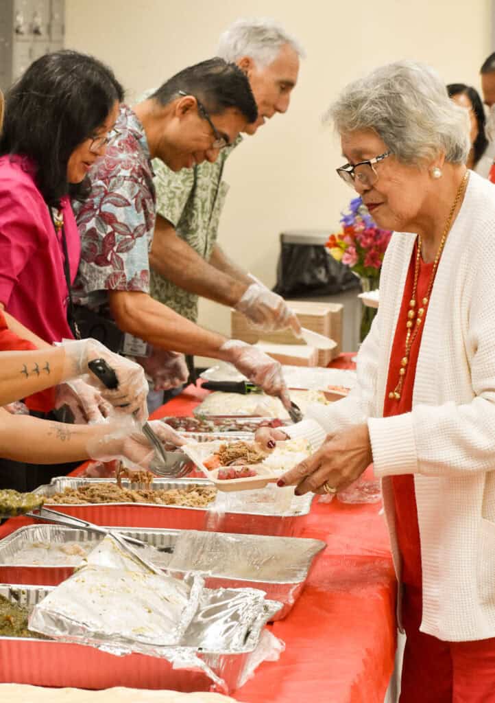 MEO Board Member Tessie Segui gets her lunch, served by MEO staff.